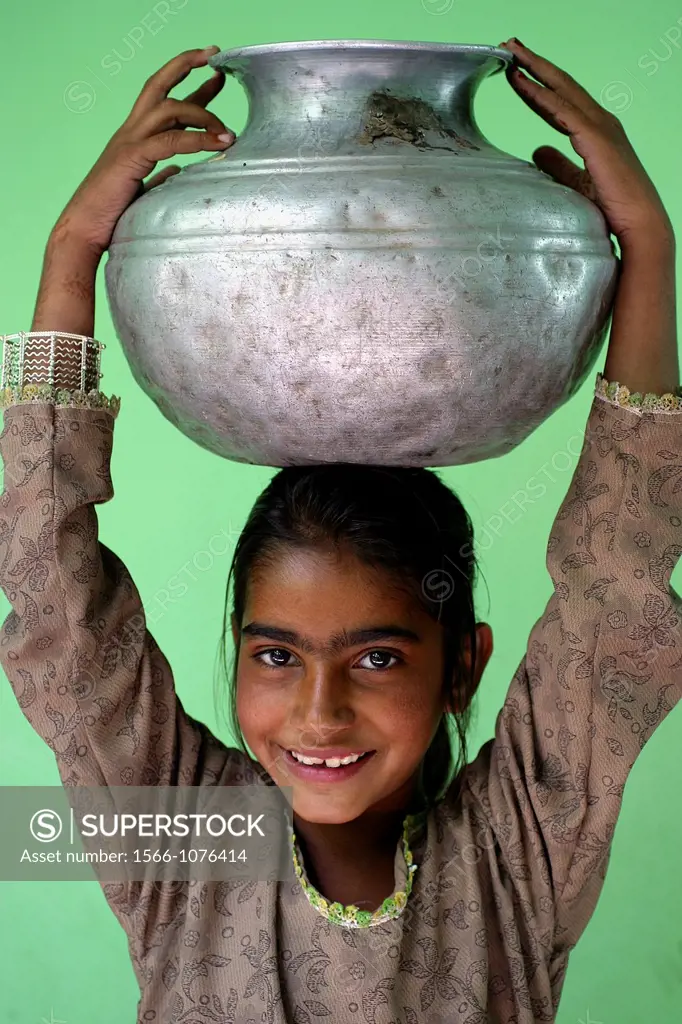 Girl carrying a pot of water coming from the well Saidpur, Kashmir, Pakistan On 8 october 2005, a severe earthquake hit Northern Pakistan Pakistan con...
