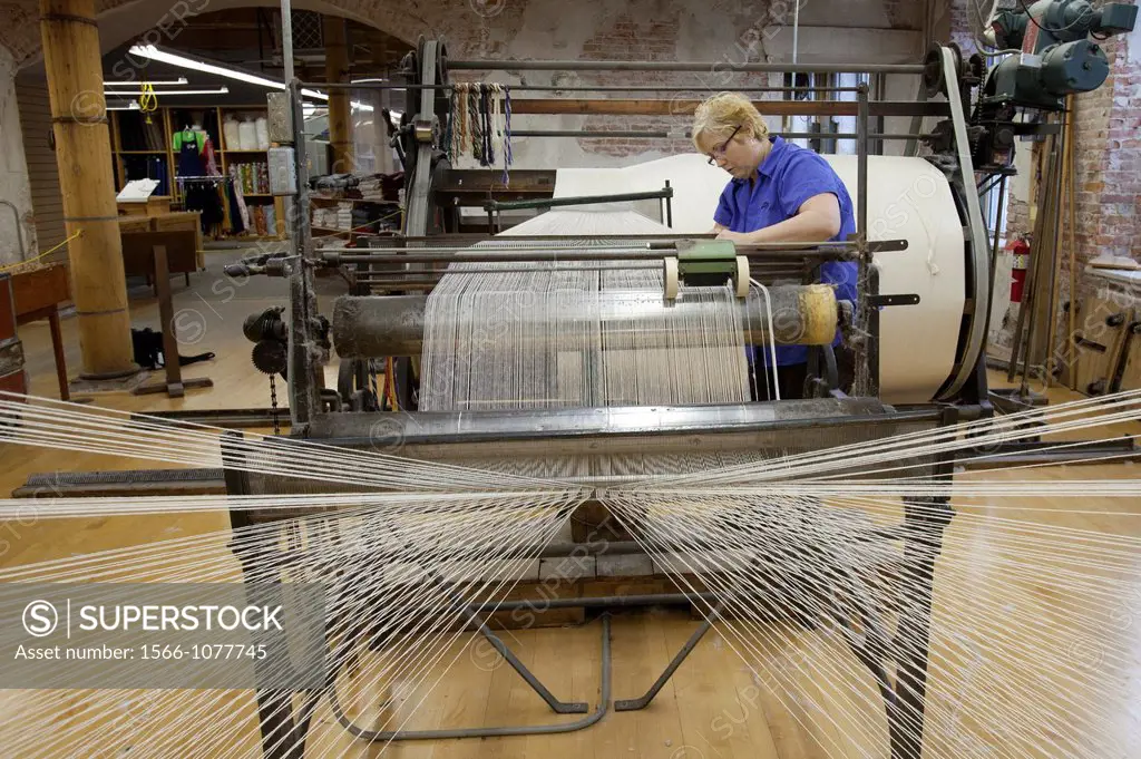 Amana, Iowa - A worker runs a warping creel at the Amana Woolen Mill  The machine gathers up to 240 strands of yarn that will later be woven into clot...