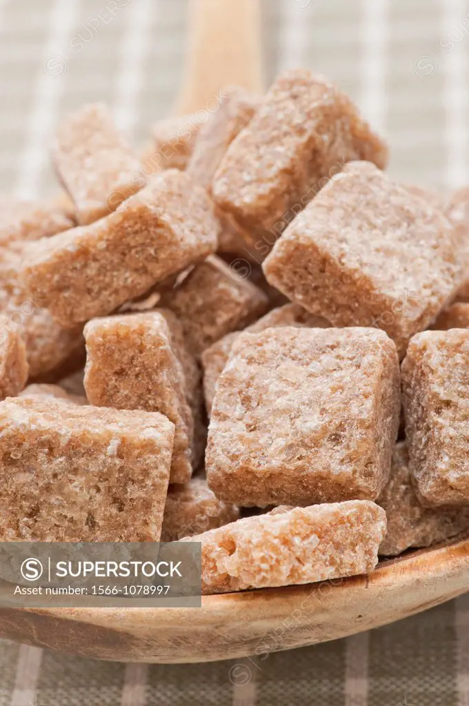 Brown sugar cubes on a wooden spoon