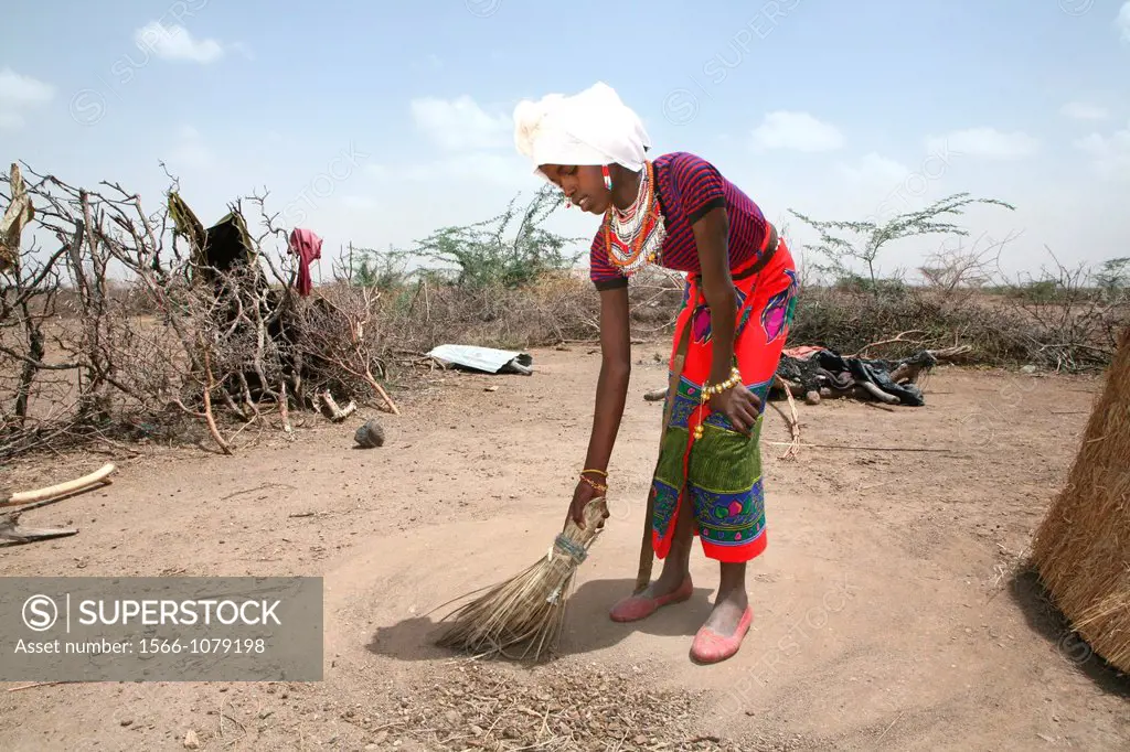 Ethiopian girl cleans the compound of her house
