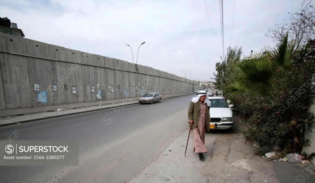 A man walks near the wall Israel is building around the west bank territories, blocking access for Palestinians who feel imprisoned by it