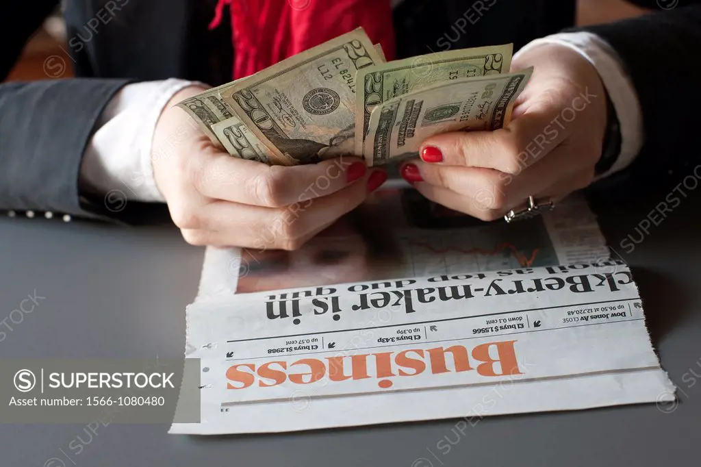 young woman hands counting U S  dollars, business, newspaper