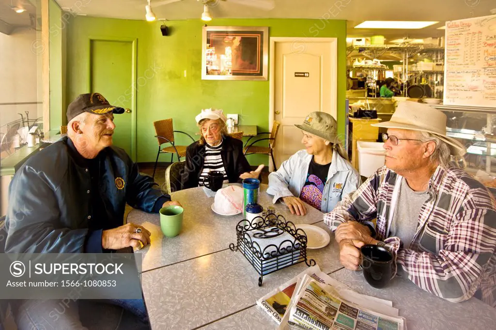 Local people their enjoy morning coffee and conversation at a Main Street restaurant in Kanab, Utah  Note sign in background