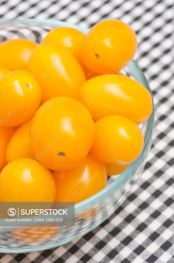 Glass bowl filled with yellow plum tomatoes