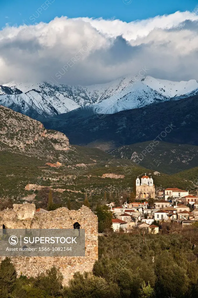 The dramatic, snow covered mountains of the Taygetos range loom over the Outer Mani village of Kambos, Southern Peloponnese, Greece