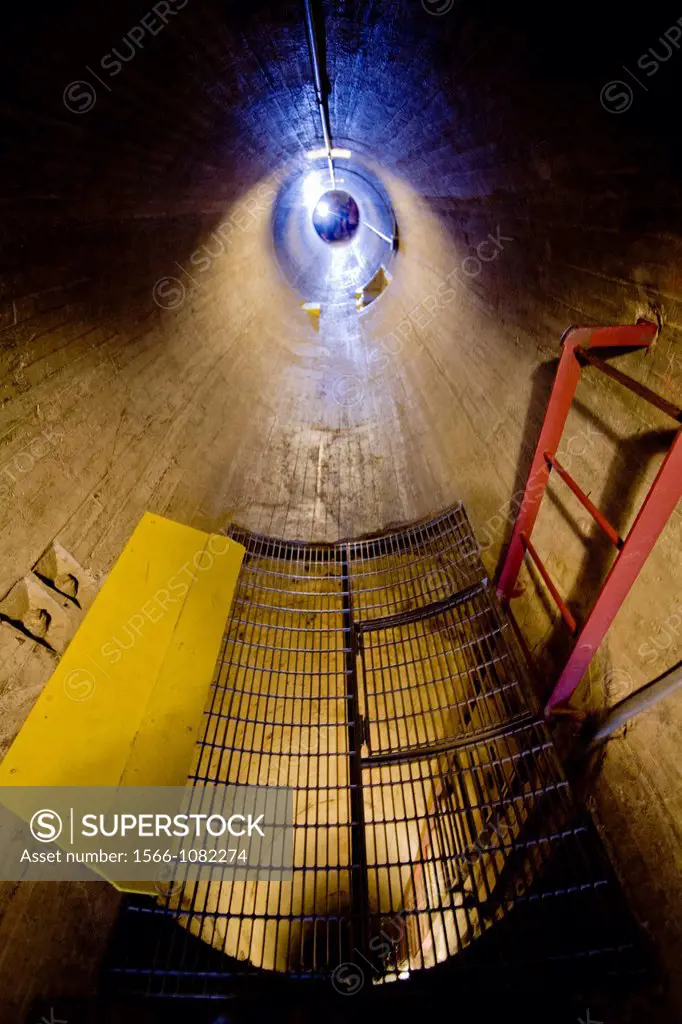 Lights shine down an inspection tunnel at Hoover Dam on the Colorado River  Note workmen in background