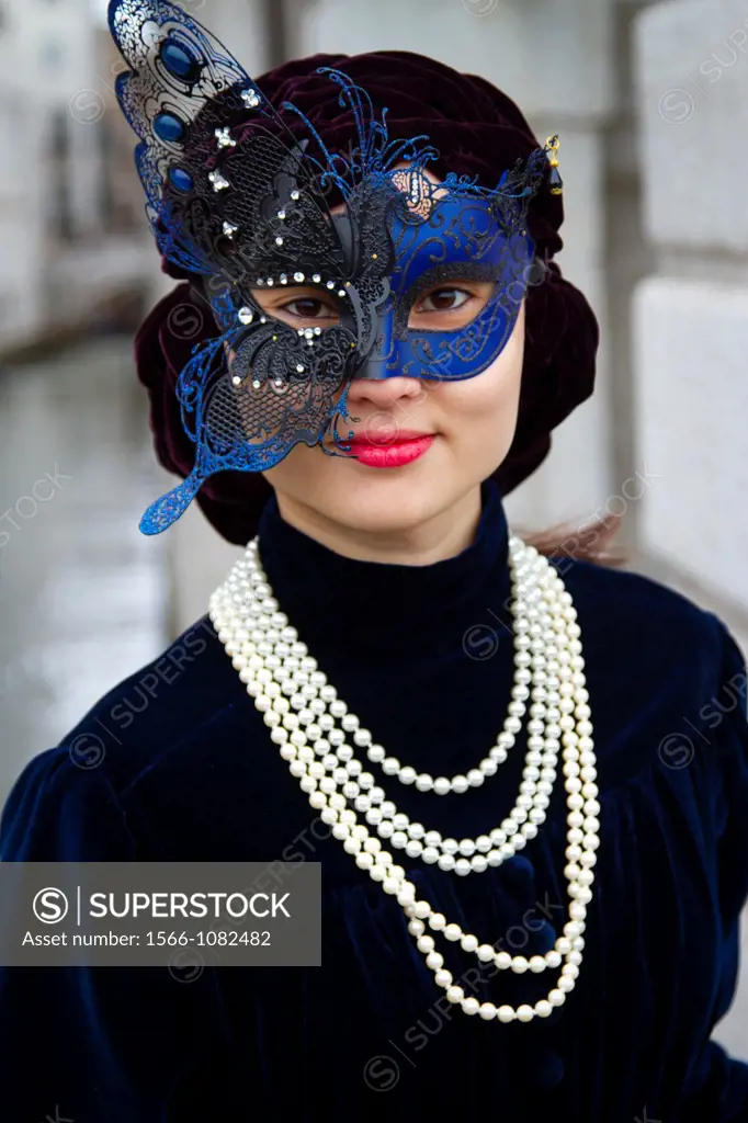 asiatic woman with mask and fancy dress in carnival Venice, Italy