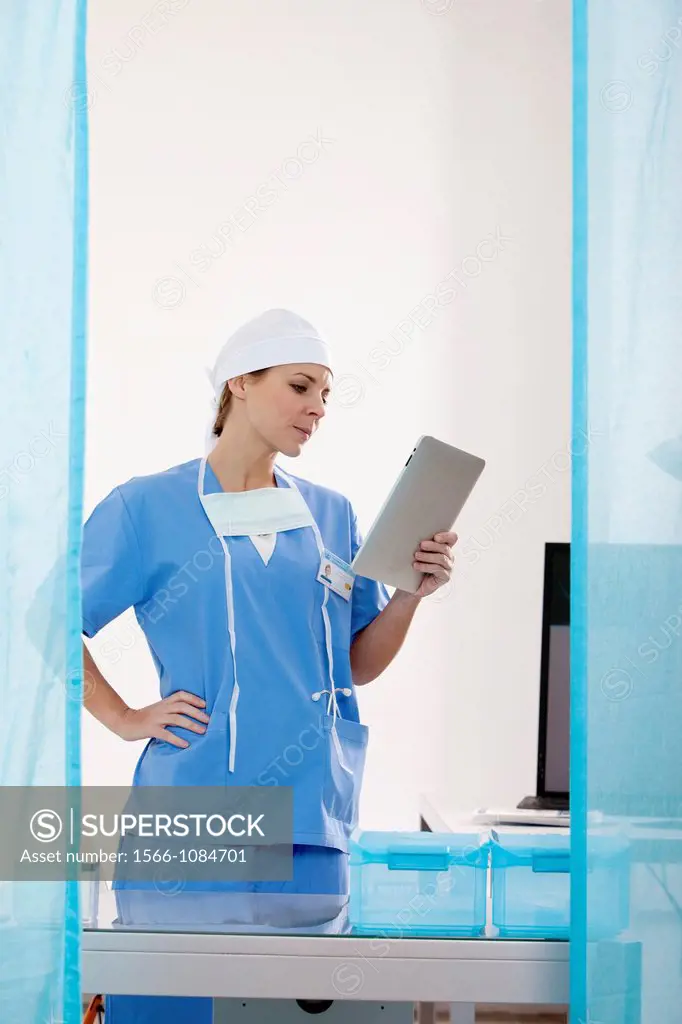 Female Nurse reviewing medical records on a tablet computer