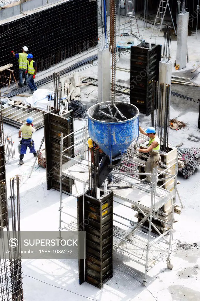 Pouring concrete on the inside of a mold to produce a column of a new building