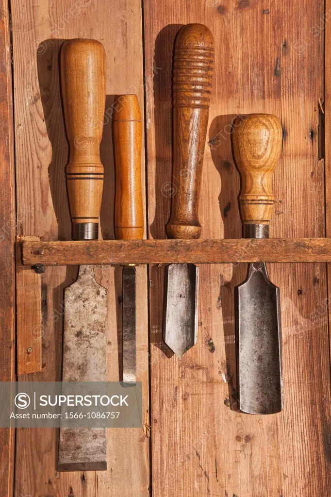 Various tools for woodworking hanging on a wooden wall