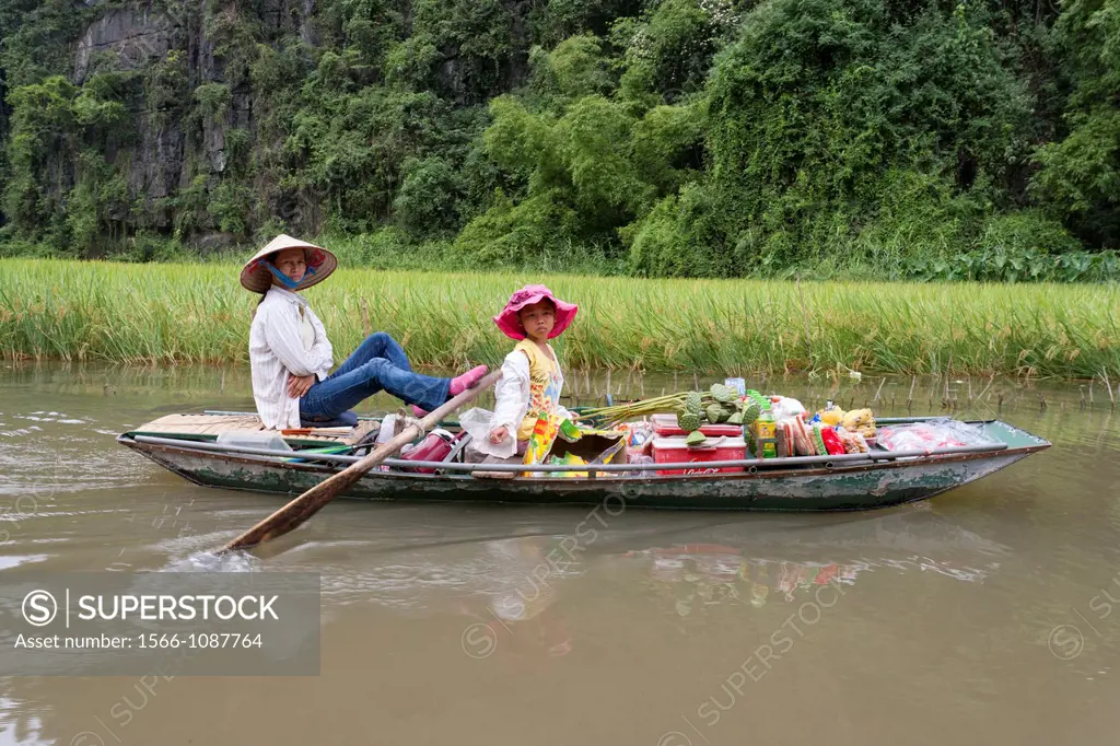 Woman paddling on the river to the market in Ninh Binh Area of northern Vietnam