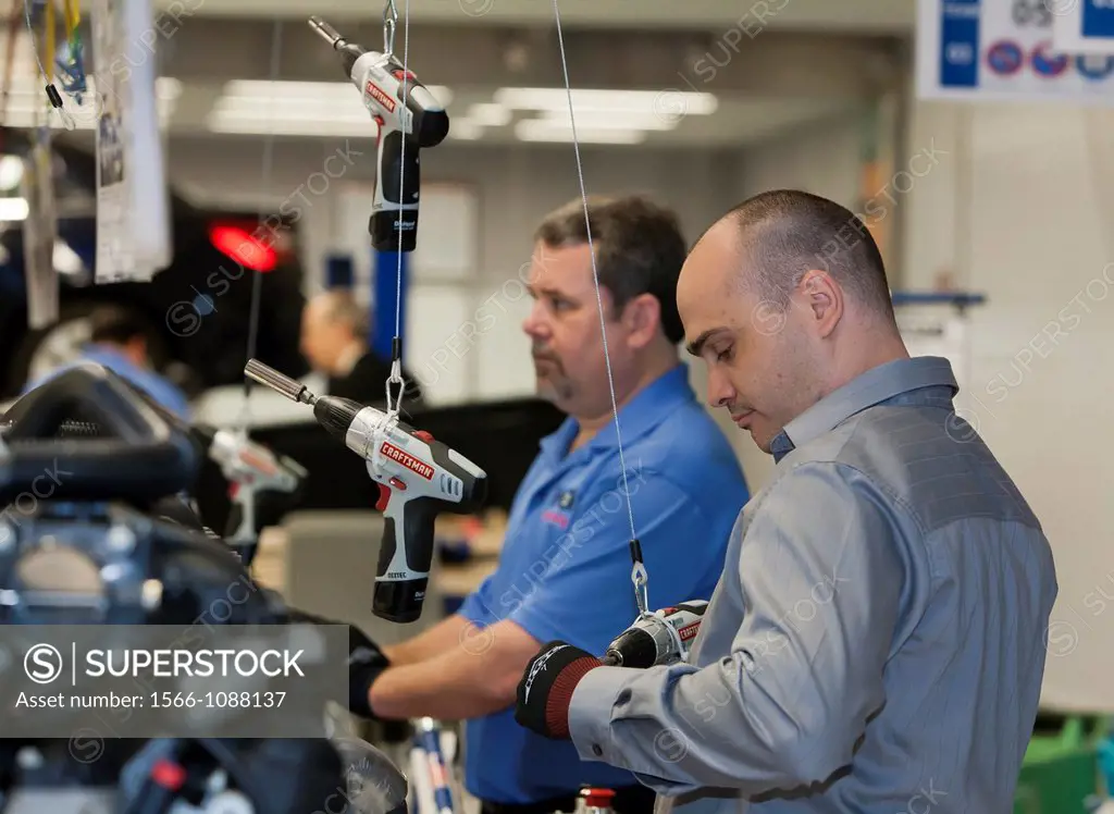 Warren, Michigan - Workers add parts to engines at Chrysler´s World Class Manufacturing Academy  The man on the right is using older methods which req...