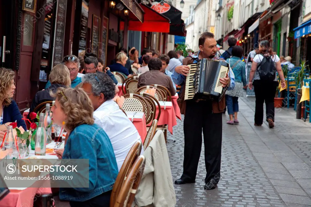 Accordion player entertains lunch time diners in Paris, France