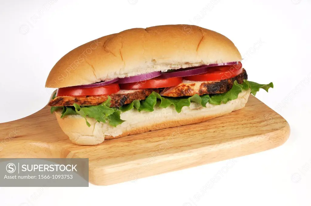 Sliced roasted chicken salad sandwich with lettuce, tomatoes and onion on deli sub roll