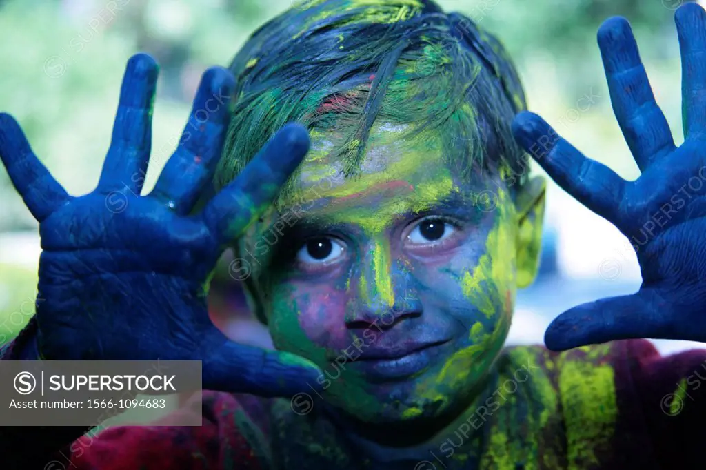 Festival of Holi is celebrated in India with colors  People smear each other with colors  A young boy shows off his colored face and hands