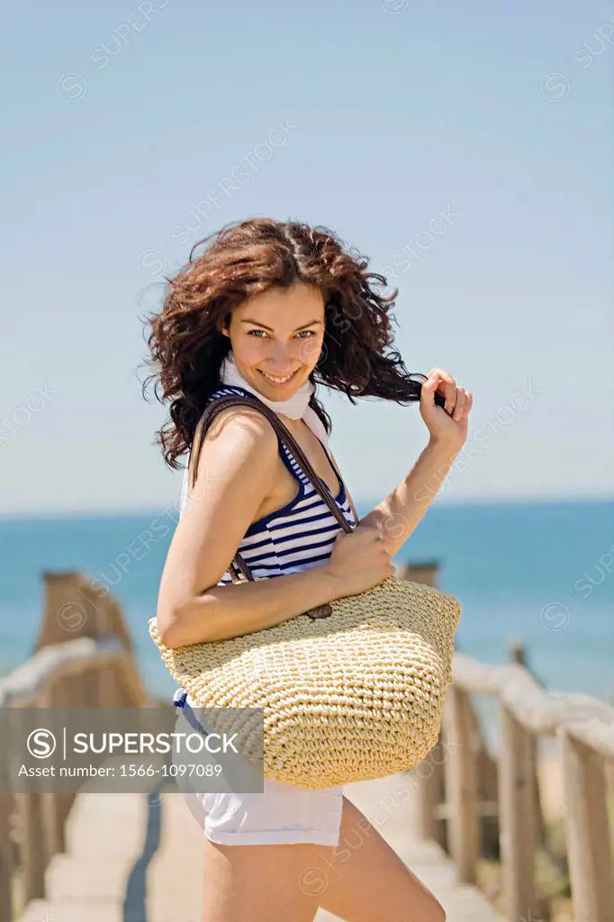 Woman arriving at the beach and smiling at camera