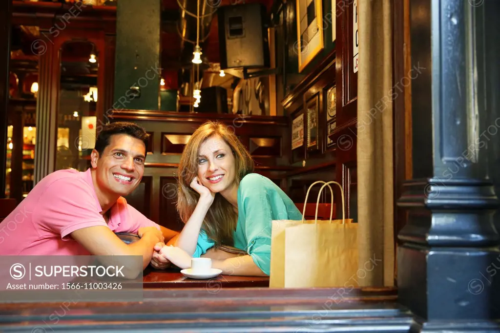 Couple with shopping bags in a coffee bar. San Sebastian. Donostia. Gipuzkoa. Basque Country. Spain.