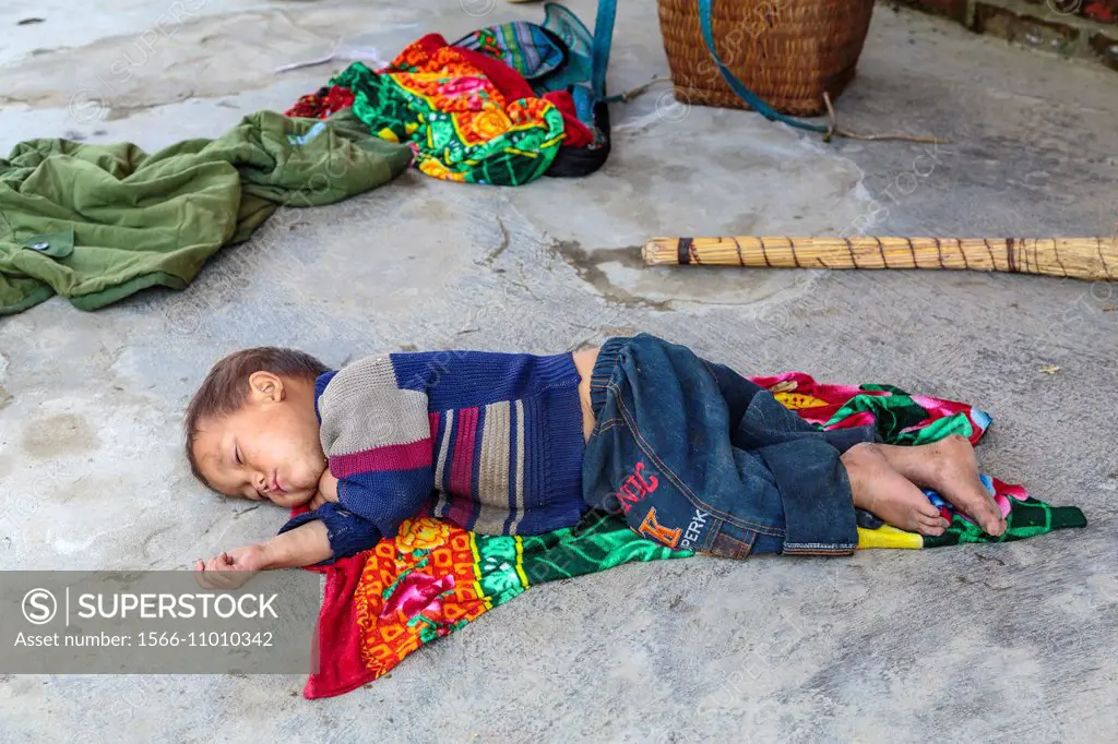A small boy sleeping on the floor in the village of Lao Chai near Sapa, Vietnam, Asia.