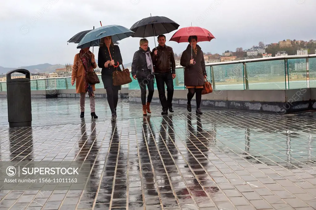 People with umbrella. La Concha Bay. Donostia. San Sebastian. Gipuzkoa. Basque Country. Spain.