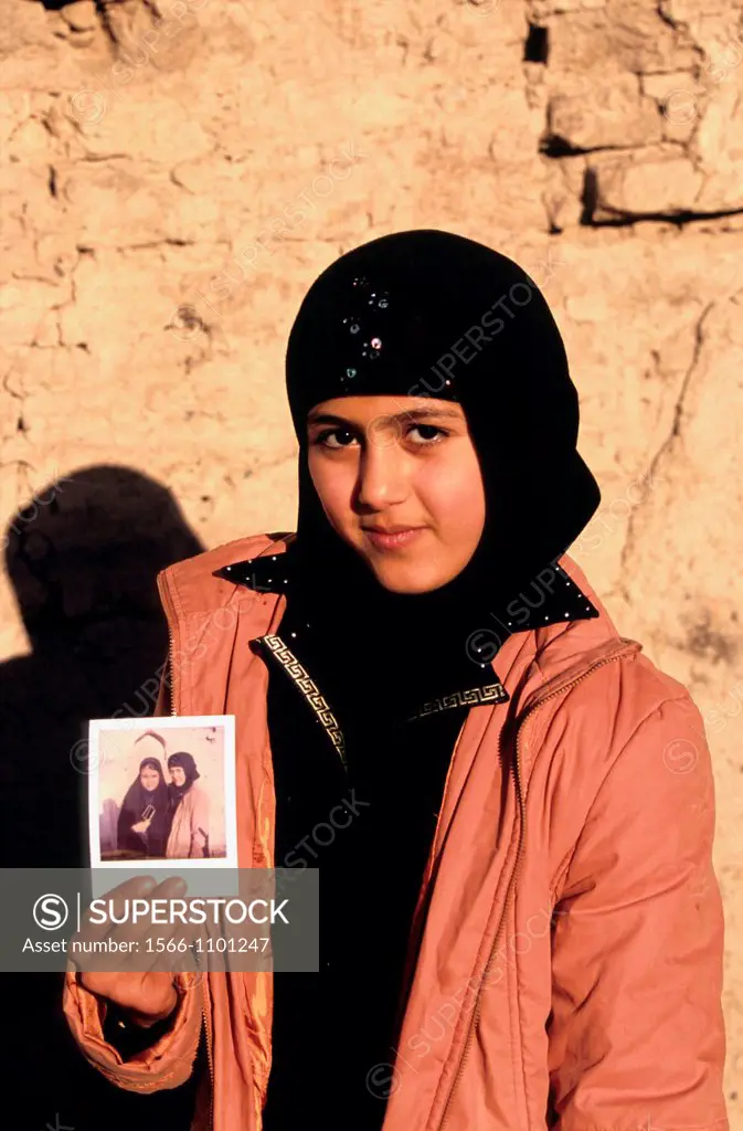 Portrait of young iranian girl showing a polaroid, Iran