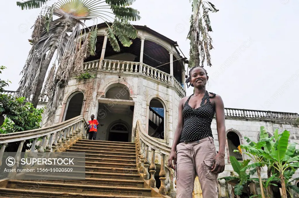 young woman beside the former ruined hospital of the roca plantation Agua Ize, Sao Tome Island, Republic of Sao Tome and Principe, Africa.