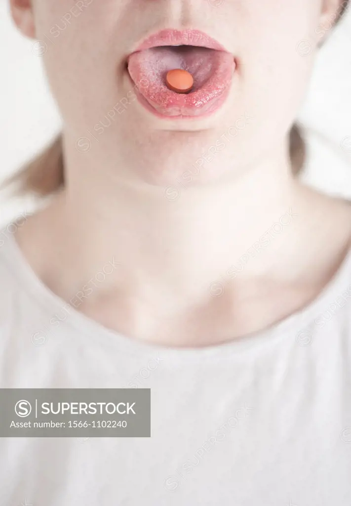 Woman with a pill on her tongue