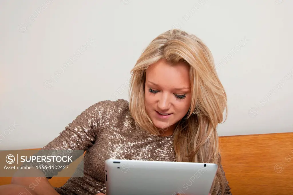 Young woman, 18-25 years, using digital tablet in a hotel room