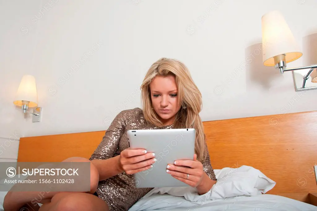 Young woman, 18-25 years, using digital tablet in a hotel room