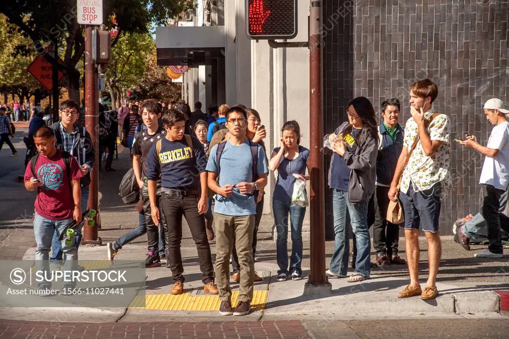 Multiracial University of California students wait to cross Durant Avenue in Berkeley, CA.