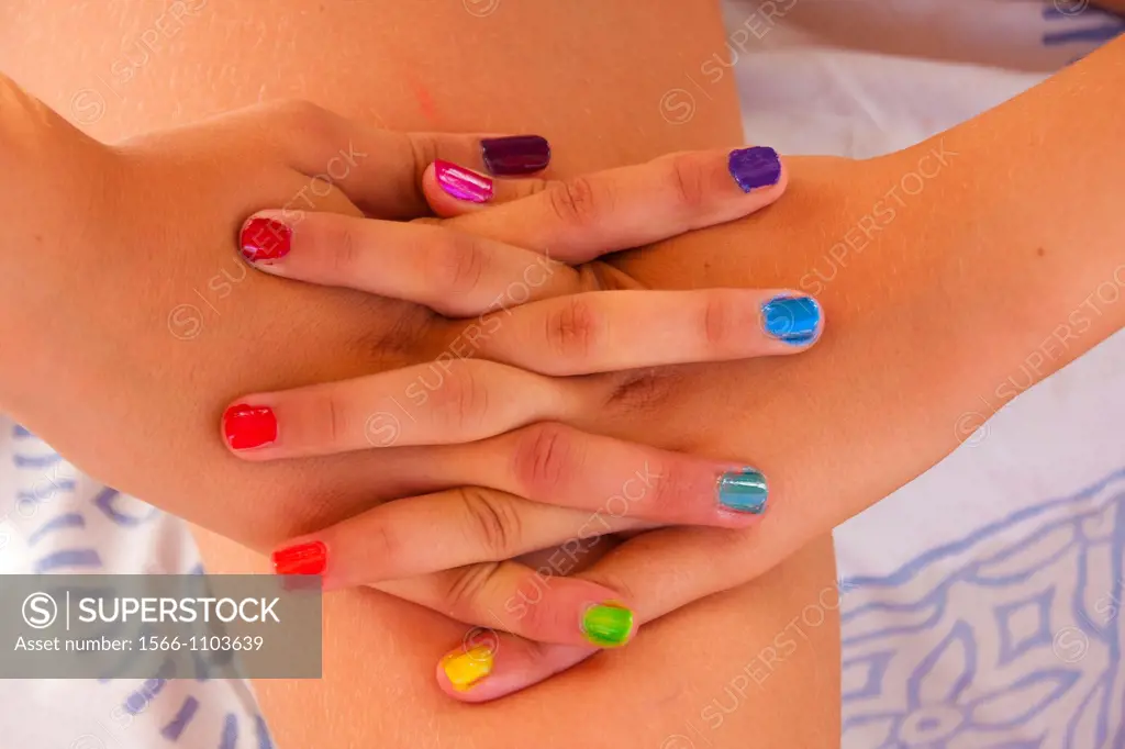 Hands of young girl with colors nails