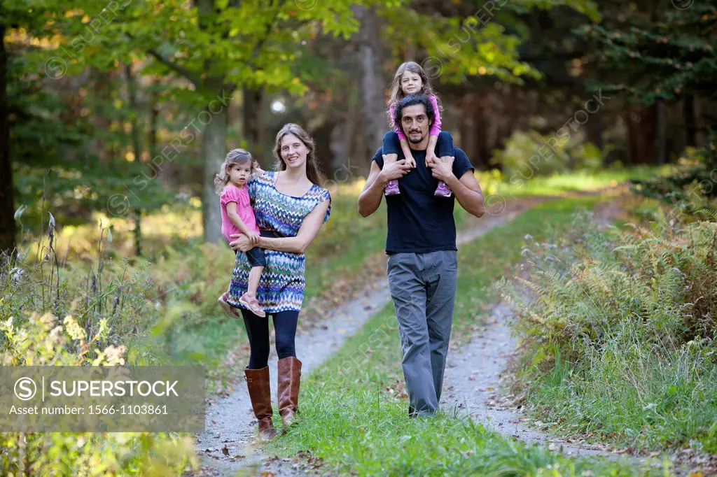 Family of four walking down country road