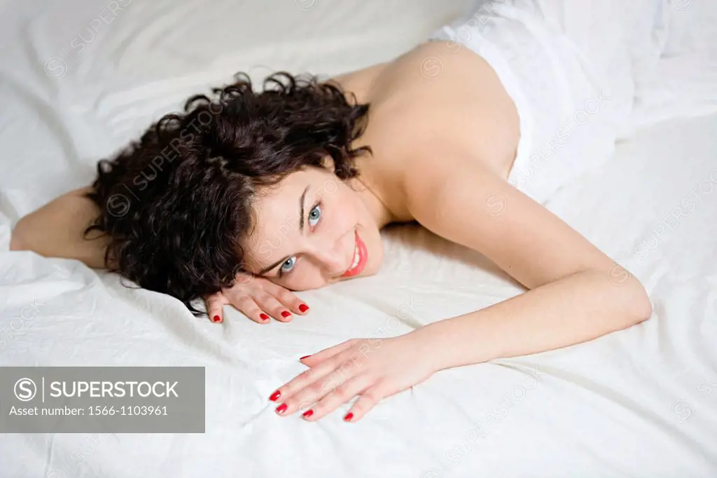 Portrait of a beautiful brunette woman in bed