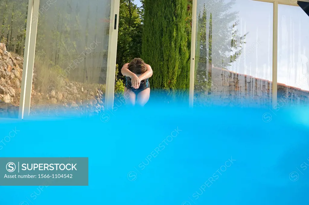 Girl about to plunge into a swimming pool