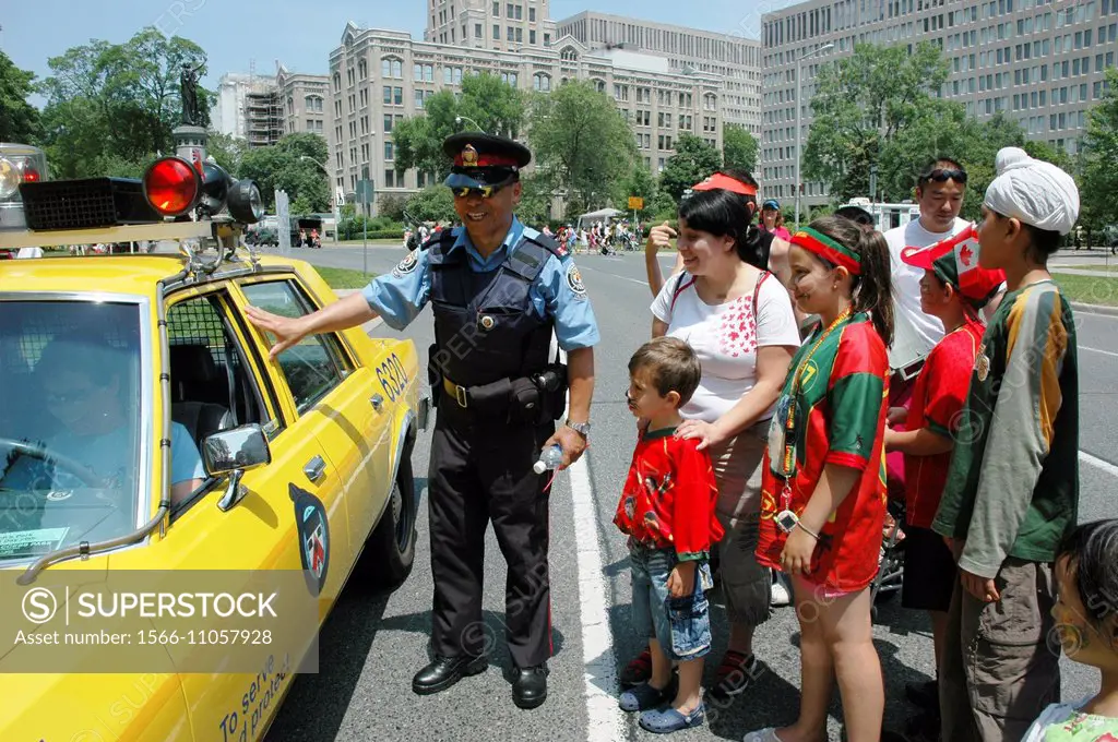 Toronto Canada: a cop showing his car to children during Canada Day´s commemoration, 1st July