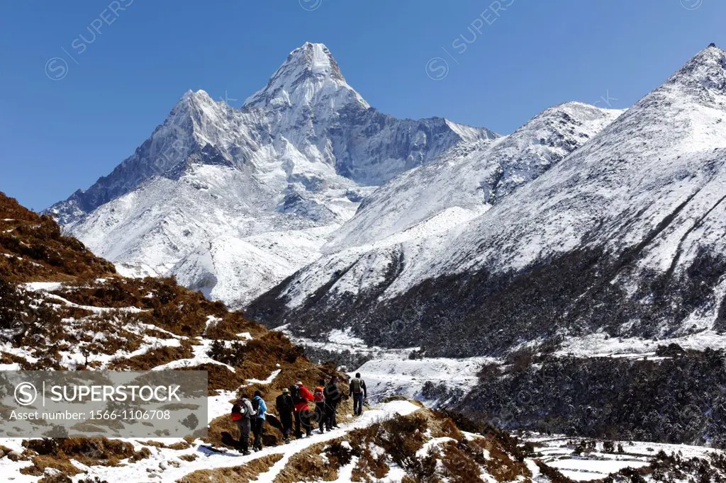 Trekkers walking below Ama Dablam mountain, Everest Region, Nepal