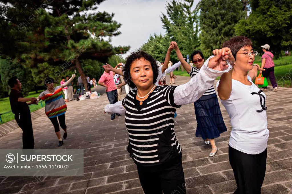 Chinese people dance at the Temple of Heaven Park during summer in Beijing, China
