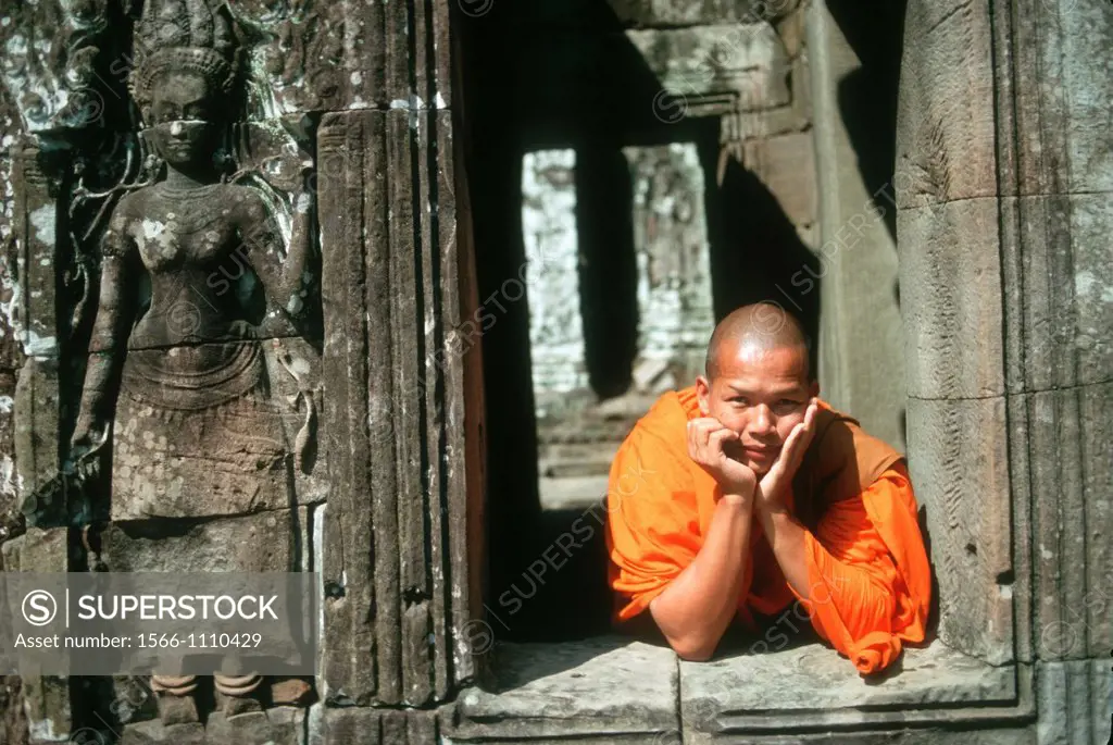 Young Buddhist monk on a window at Angkor Wat