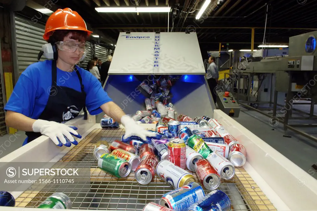 Worker sorts cans to be recycled at a recycling plant