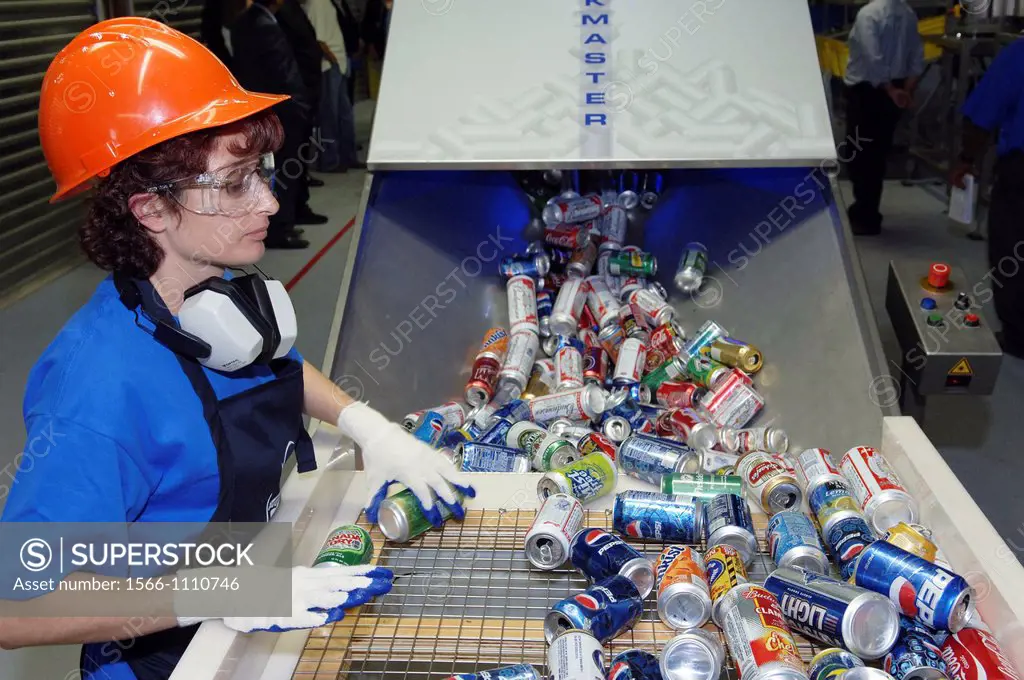 Worker sorts cans at a recycling plant