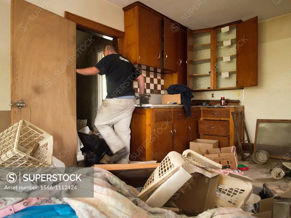 A man clears items out of a foreclosed house in Woonsocket, Rhode Island, United States