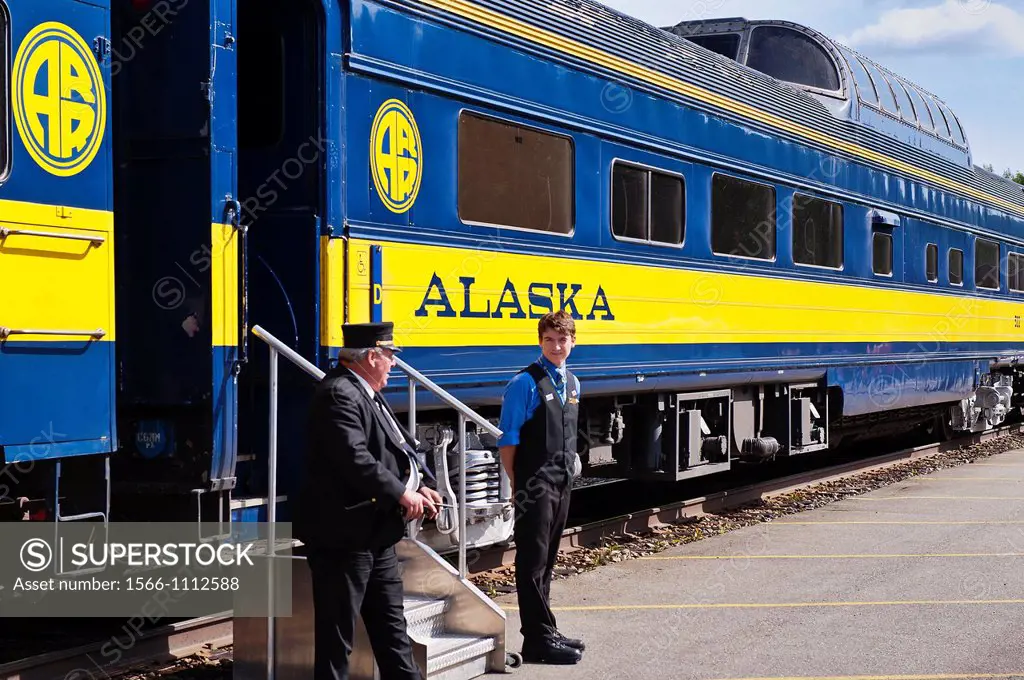 Conductor and clerk await passangers aboard an Alaska Railroad train, USA