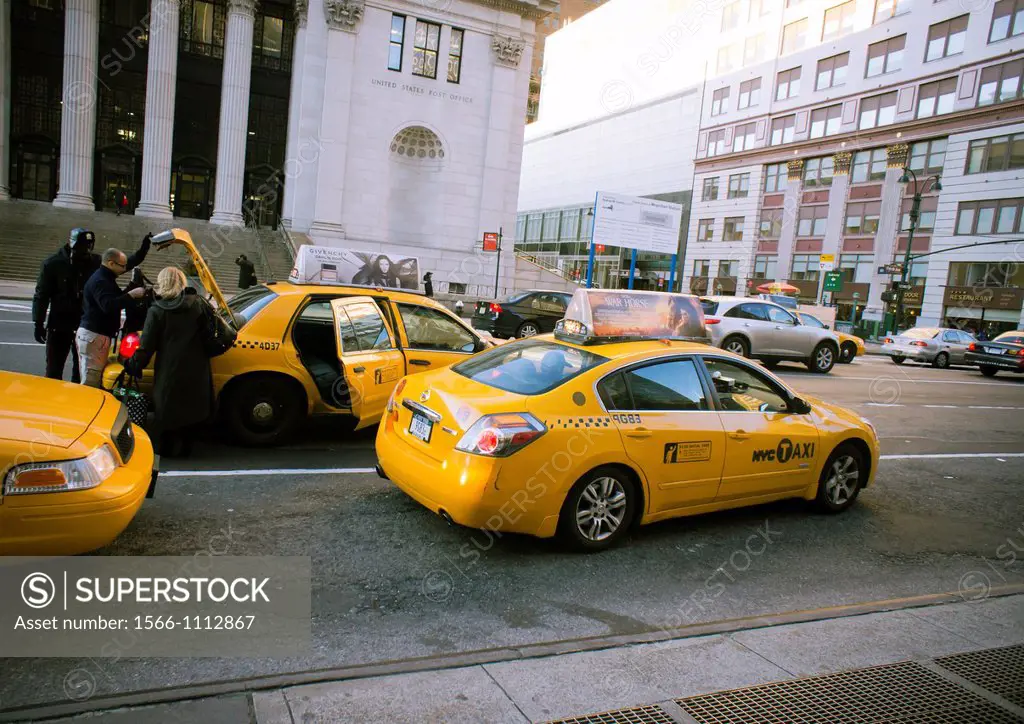Travelers load luggage into a taxi outside of Pennsylvania Station in New York