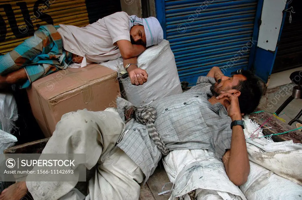 Delhi, India: tired porters sleeping at Chandni Chowk market.