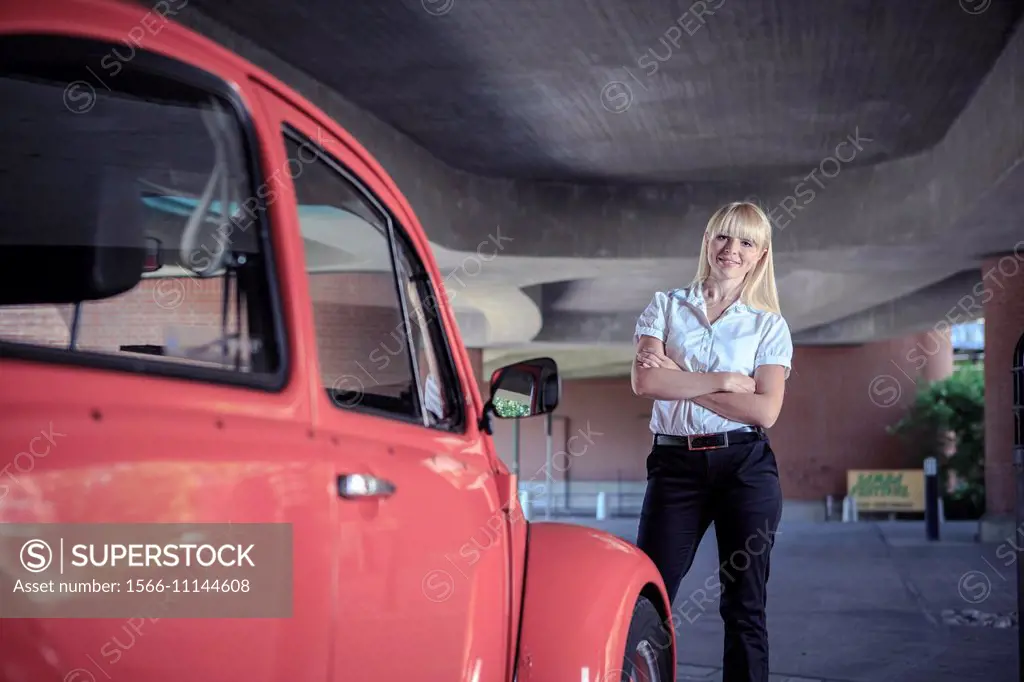 urban portrait of a young woman with a classic car.