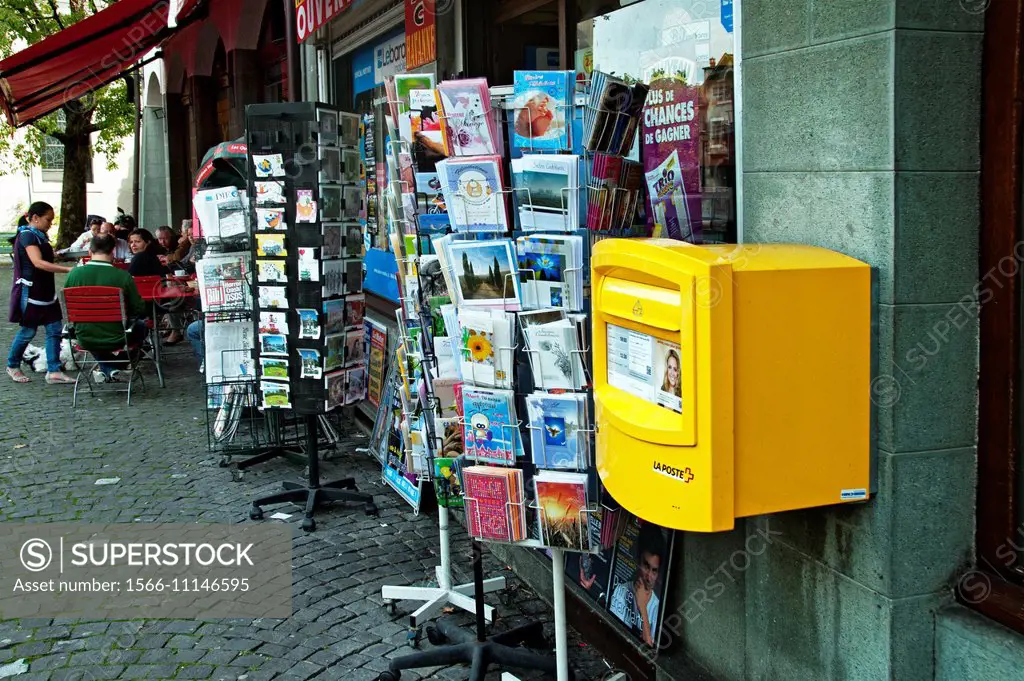 street scene, kiosk with press, cigarettes, post cards, postbox, coffee bar outdoor tables in far background, Geneva, Switzerland