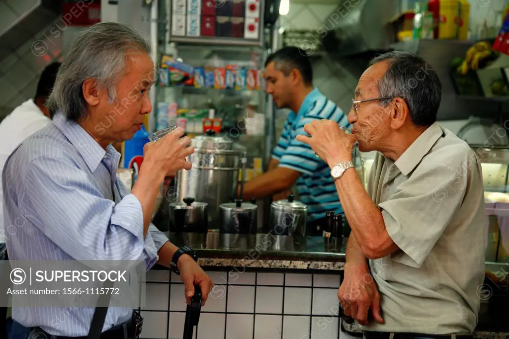 Two men drinking coffee at Liberdade, the Japanese quarter, Sao Paulo, Brazil