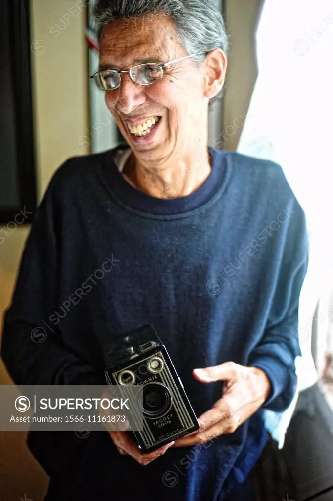 Cuban photographer Julio Bello, holding his first camera, an old Brownie camera at his home in Havana.