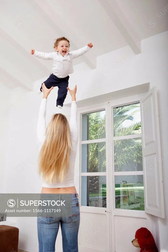 Mother throwing her one year old boy in the air