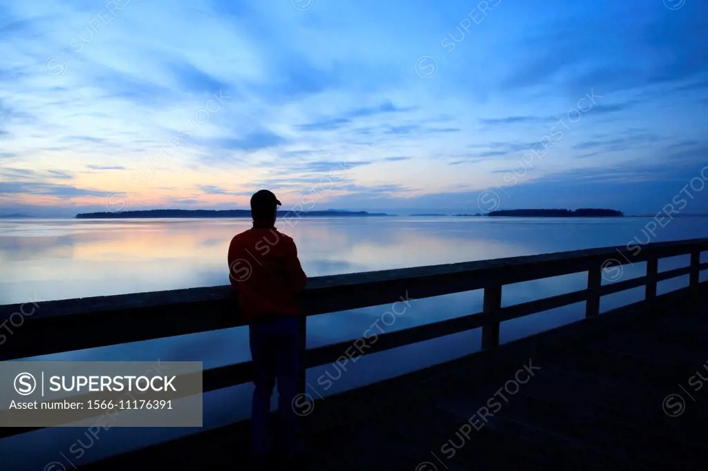 Person on fishing pier at dawn, Sidney, British Columbia.