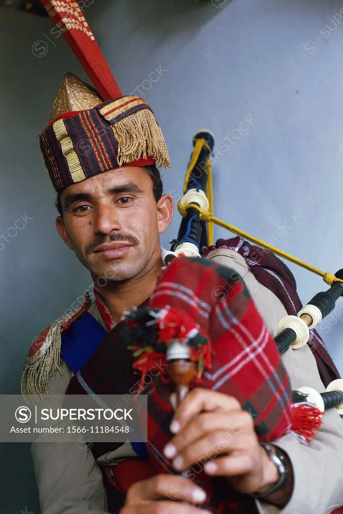 A man wearing a military uniform is playing bagpipe. Pakistan.